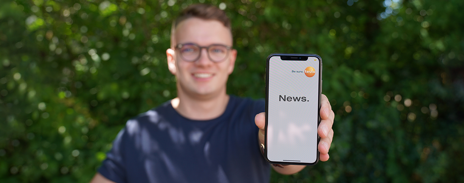 The news section of Testo Industrial Services. A Testo employee shows the news section on his smartphone.
