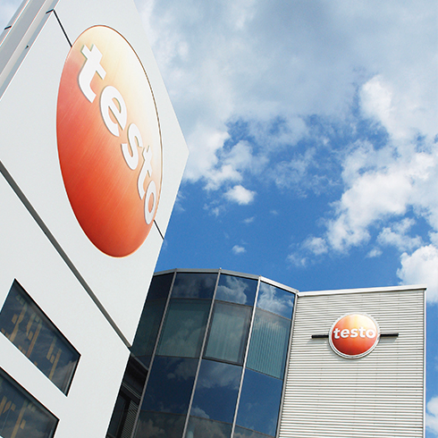 More service, more security for the future of our company Testo building with logos under a blue sky