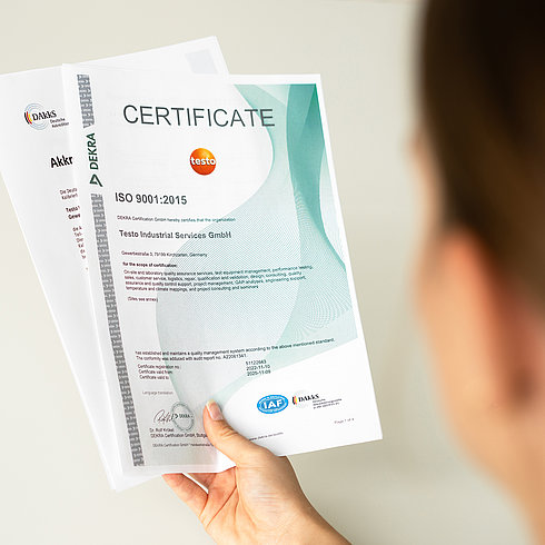 ISO 9001 Testo Industrial Services Employee holds certificate in her hand