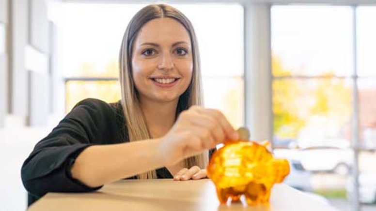 A Testo employee feeds his piggy bank with money.