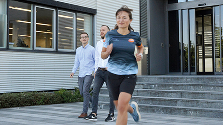 Testo offers exclusive employee benefits for health and sports. A Testo employee jogs in a Testo jersey.